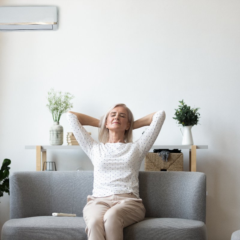 woman enjoying the air conditioning in her home